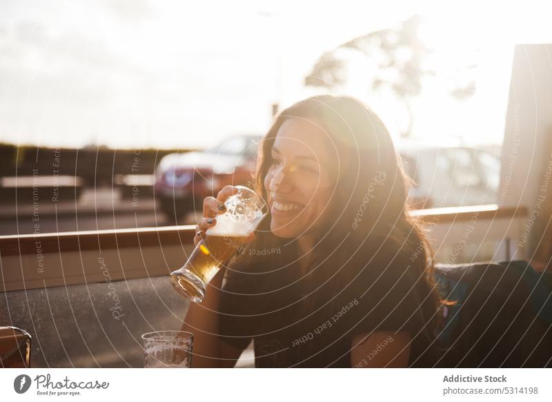 Happy woman drinking beer in cafe smile positive happy street casual beverage portugal cheerful female young rest enjoy relax lifestyle glad chill leisure