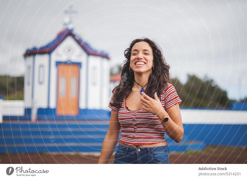 Cheerful young woman smiling with eyes closed happy church countryside building smile hill cheerful nature casual religion azores portugal positive cathedral