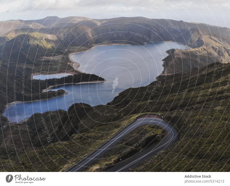 Aerial view of curved road in landscape with lake and mountain range highland roadway countryside ridge scenery portugal azores nature hill route green scenic