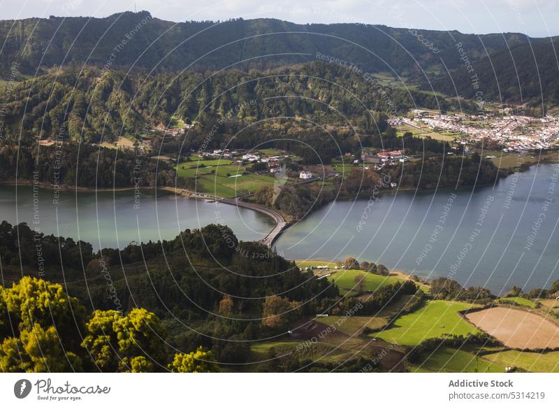 Picturesque view of river in green valley with forest and residential settlement lake picturesque hill countryside nature village water rural landscape aerial