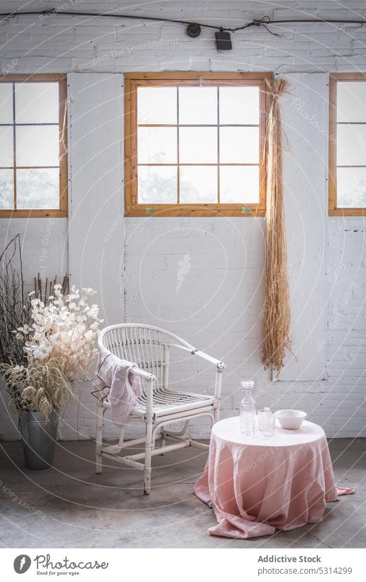 Chair near table with napkin against windows chair decor flower furniture apartment interior room brick wall design vase home wooden white decoration house