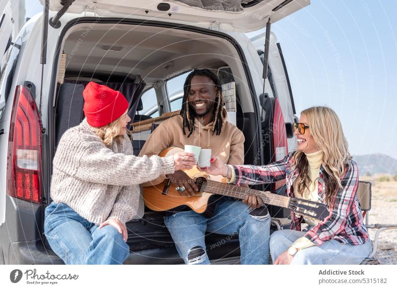 Group of friends having fun with guitar together play friendship music smile cheerful instrument happy van summer joy nature relax weekend rest casual car