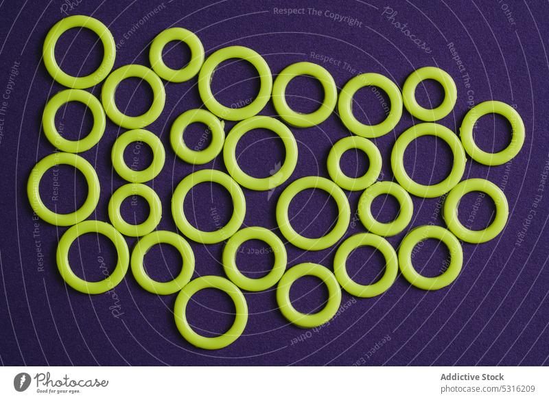 Colorful plastic rings on purple surface circle colorful modern creative bright beautiful art minimal fantasy texture background shape design abstract element