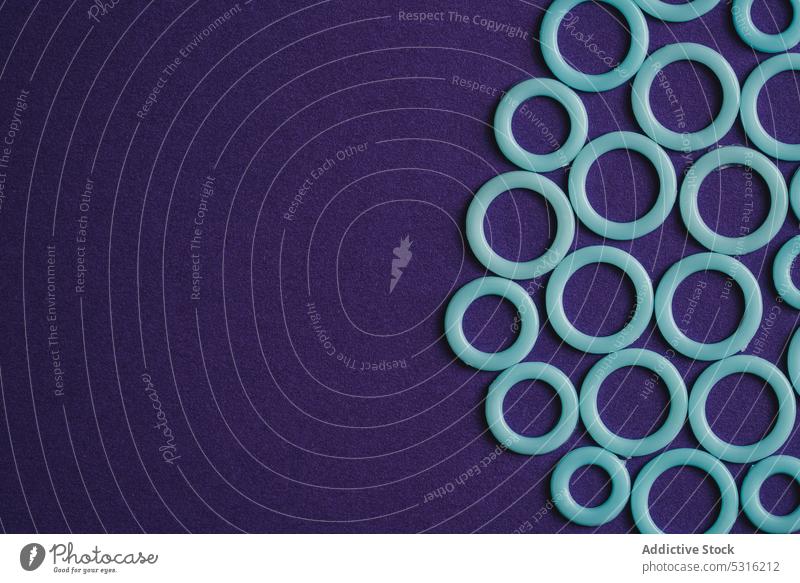 Colorful plastic rings on purple surface circle colorful modern creative bright beautiful art minimal fantasy texture background shape design abstract element