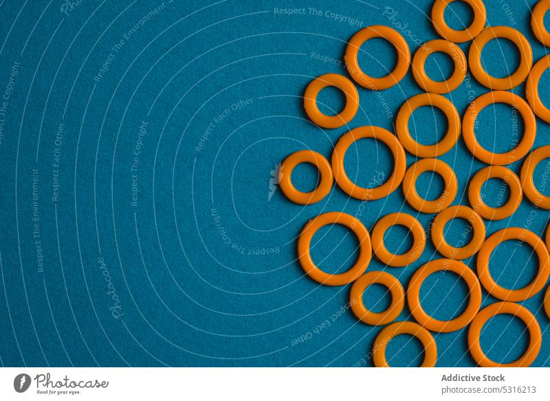 Colorful plastic rings on blue surface circle colorful modern creative bright beautiful art minimal fantasy texture background shape design abstract element