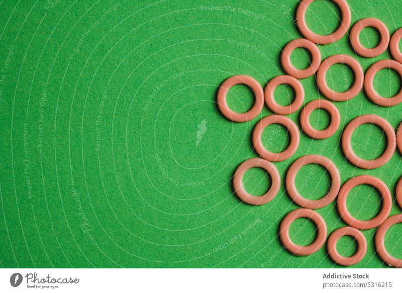Colorful plastic rings on green surface circle colorful modern creative bright beautiful art minimal fantasy texture background shape design abstract element