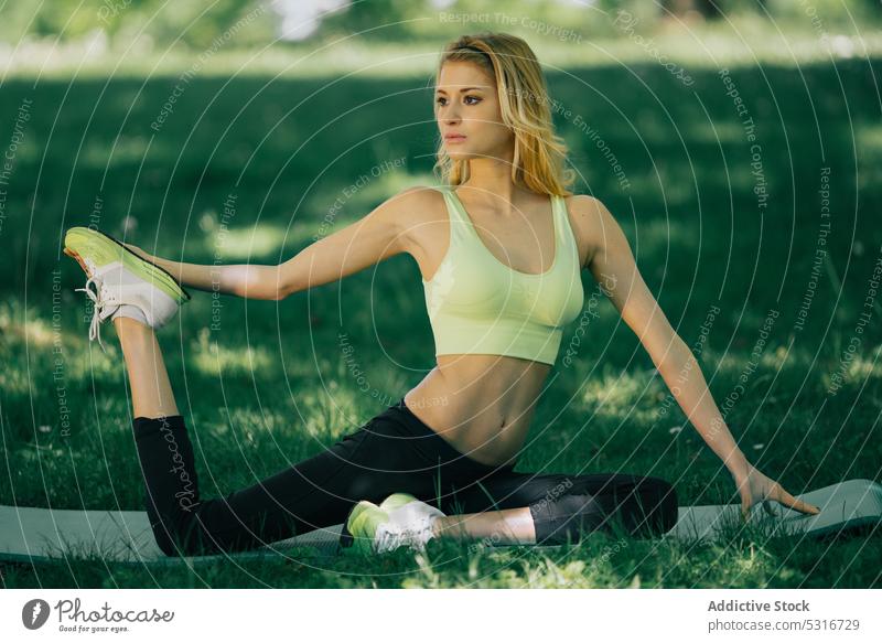 Young woman exercising in park training stretching fitness lifestyle young sport female healthy exercise athlete workout summer sunny daytime lady wellness