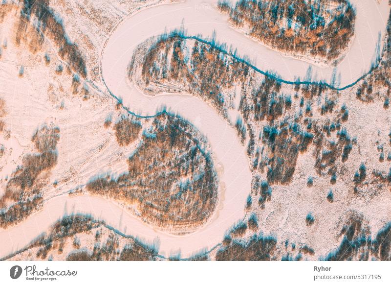 Aerial view forest woods and river landscape in winter day. Top view of beautiful european nature from high attitude in winter season. Bird's eye view aerial