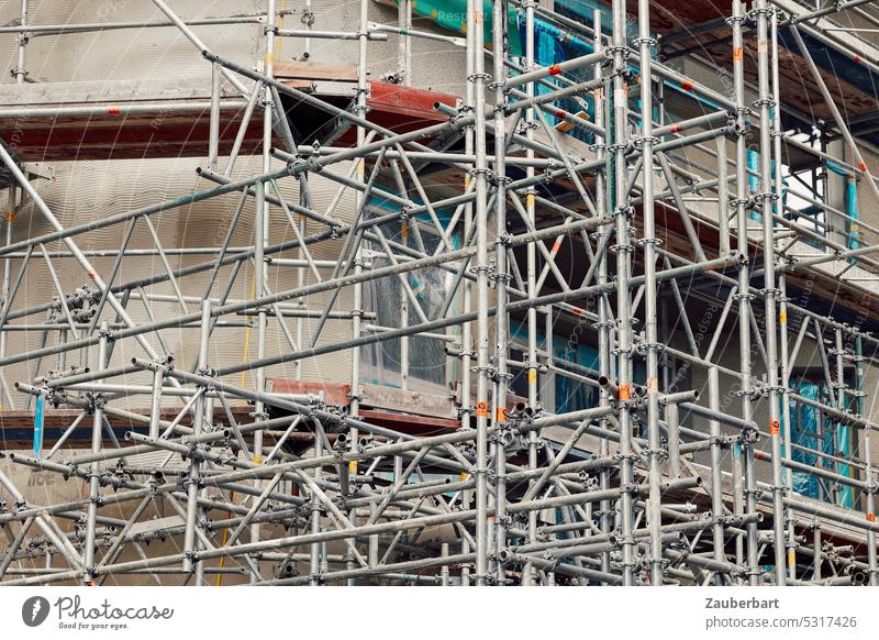 Scaffolding of a construction site, crossing lines Construction site Cross Build linkage poles Building Redevelop Modernization Redecorate Change Facade Dynamic