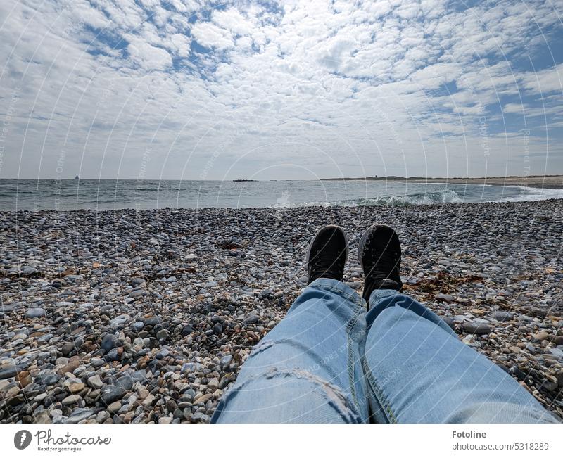 I'm sitting on the sun-heated stones of the Ade on the dune off Helgoland In front of me, the waves of the North Sea roll onto the beach. The sky is blue with little clouds. I could sit here for hours and just do nothing.