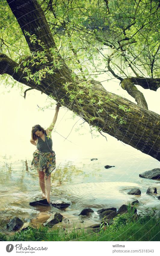 Dreamy woman standing in the water on the riverbank River bank Main Woman Water naked feet naked legs bathe Idyll romantic Barefoot Legs Relaxation Feminine