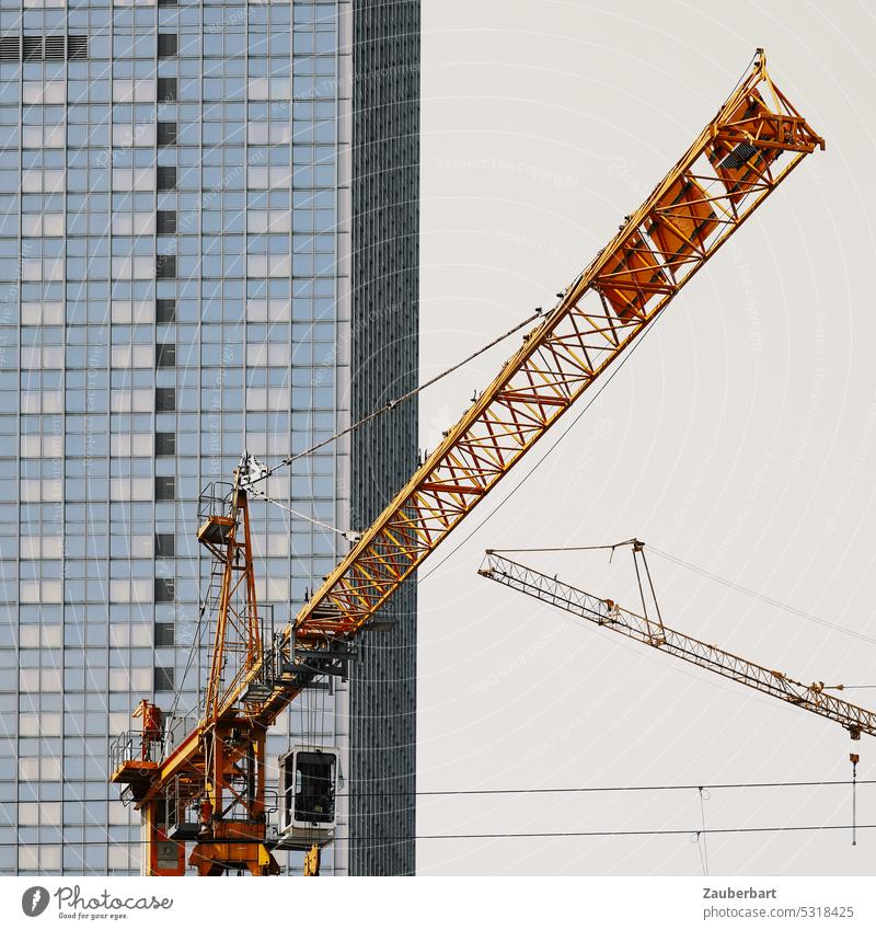 Yellow construction crane stretches in front of modern facade Crane Construction crane Construction site Build Facade Modern City centre Alexanderplatz