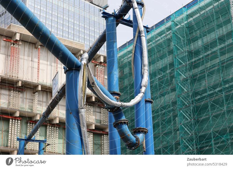 Blue drainage pipes in front of scaffolded facades of high-rise buildings at Alexanderplatz conduit Drainage pipes intersecting Construction site Facade Town