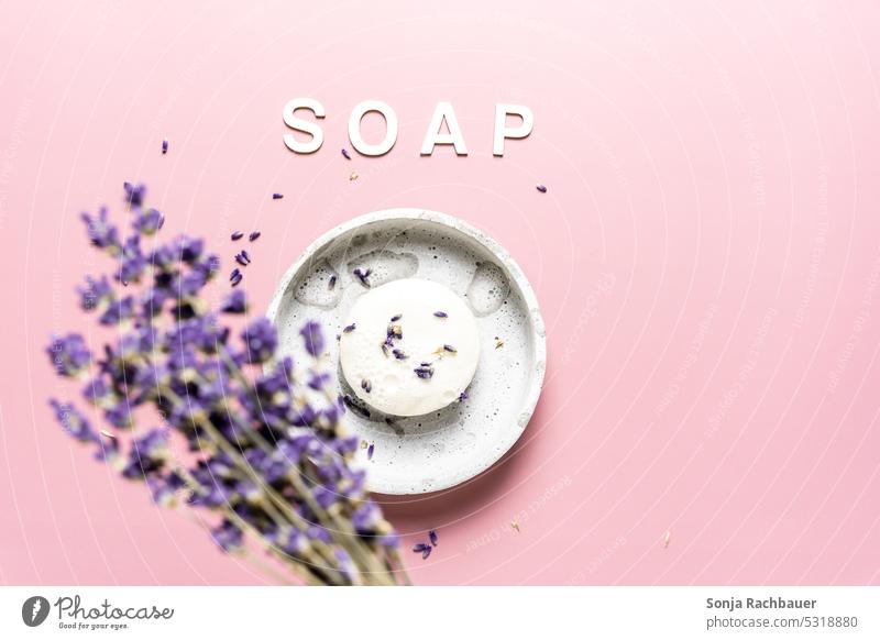 A round bar of soap with lavender on a pink background. Top view. Soap Round Lavender Foam Clean hygiene Personal hygiene plan Self-made Cosmetics Bathroom