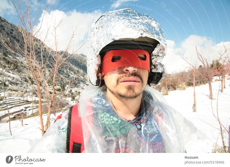 one person wearing a mask of superhero and helmet standing in snow field Winter's day snow-covered costume looking at camera outfit fantasy aspiration