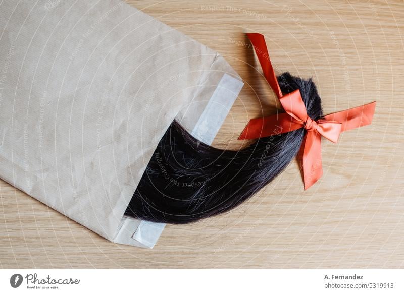 Section of cut hair in a ponytail inside an envelope. Concept of hair donation for cancer patients through mail haircut hair cut donate short hair short haired