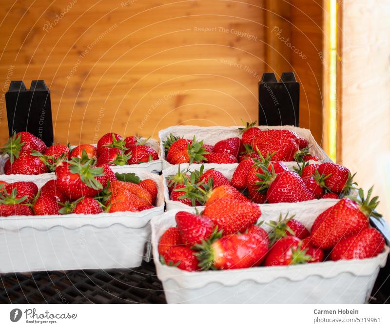 red strawberries with green stems in bowls at stall with wooden wall in background strawberry Strawberry Close-up Food Summer Fruit fruits Red Mature Delicious