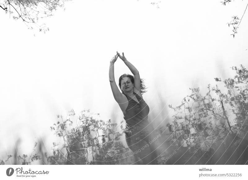 Woman dancing in harmony with nature behind tall grasses Dance Nature Experience nature Feminine Mature woman Human being To enjoy man and nature perception