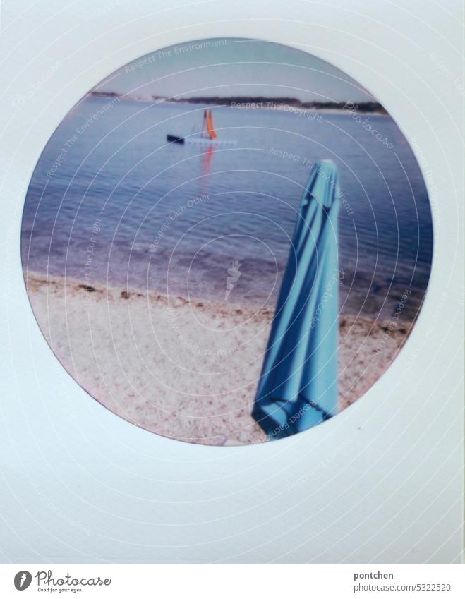 polaroid shows a light blue parasol on a stone beach and a red slide in the sea Polaroid Ocean Croatia vacation travel Sunshade Slide Red Water