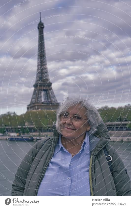 Senior woman tourist is happy in Paris in front of the Eiffel Tower Woman eiffel tower France paris eiffel tower urban travel symbol famous cityscape view