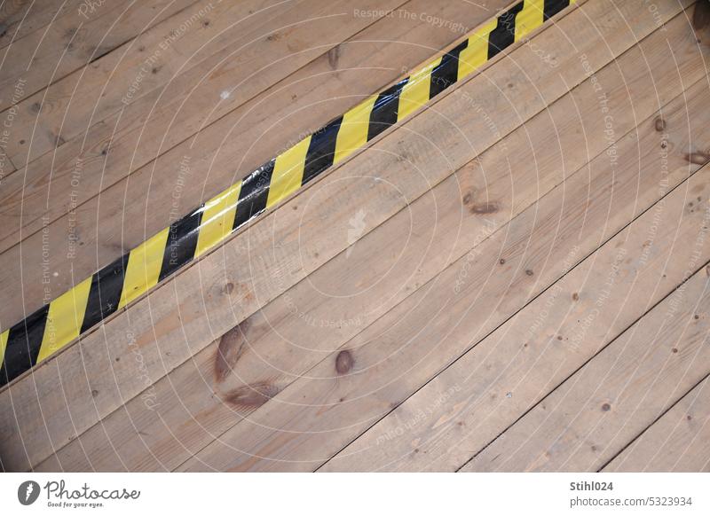black and yellow tape on wooden plank floor black-yellow yellow-black Yellow Black Adhesive tape Striped Warn peril Stumble Stumbling block Wooden floorboards