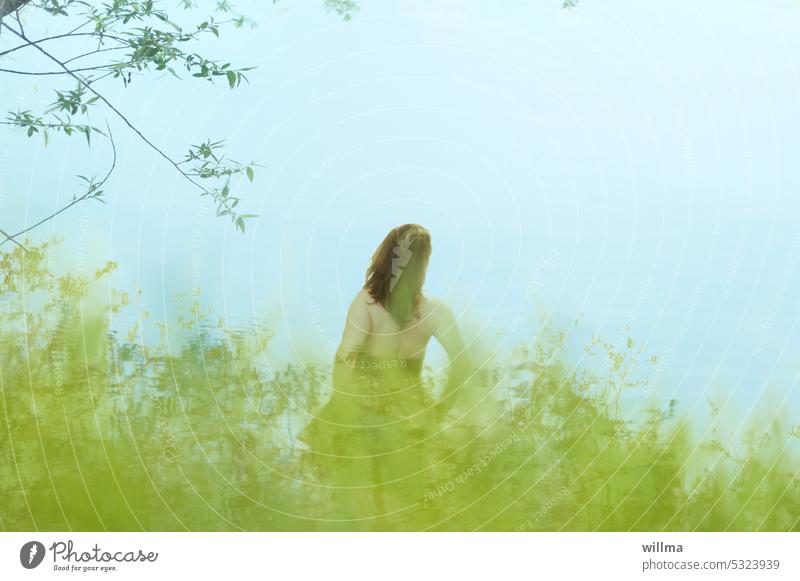 Woman looking dreamily to the other shore, back view Rear view Long-haired Brunette Backless bank Lake grasses River bank Lakeside Water Nature Dreamily