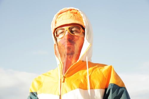 photo concept about a person wearing a sport outfit and orange hat with transparent mask and funky glasses without glass lifestyle garment colorful cloth