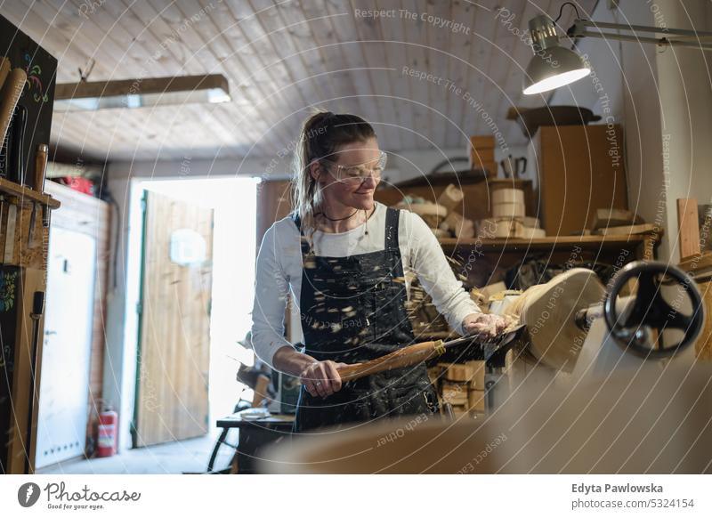 Craftswoman carving wood in a carpentry workshop real people woodshop carpenter entrepreneur expertise craftsperson creativity manufacturing crafts people hobby