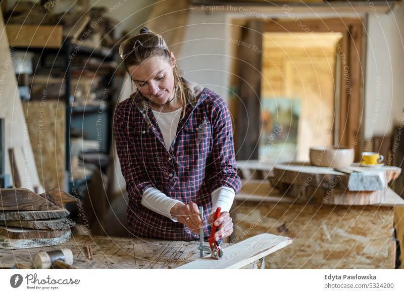 Craftswoman working with wood in carpentry workshop real people woodshop carpenter entrepreneur expertise craftsperson creativity manufacturing crafts people