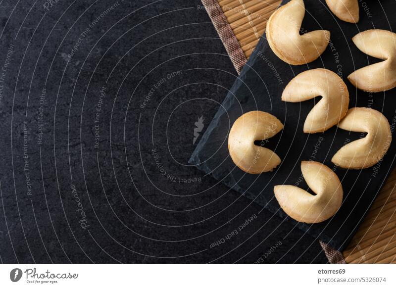 Traditional fortune cookies black slate background asian bakery blank chinese closeup concept crispy culture dessert food luck message note paper predict snack