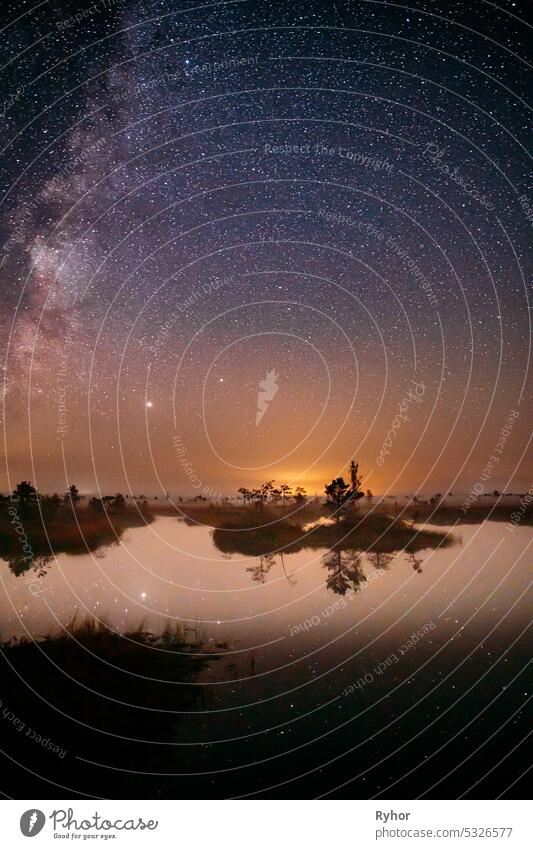 Milky Way Galaxy In Night Starry Sky Above Rural Landscape In Summer Season. Real Colorful Night Stars Above Swamp. Amazing Glowing Stars Effects Above Landscape