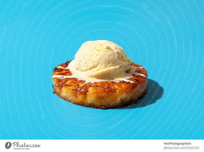 Grilled pineapple with vanilla ice cream, isolated on a blue background alkohol ananas barbeque bright brown caramel cognac color cooked copy space cuisine