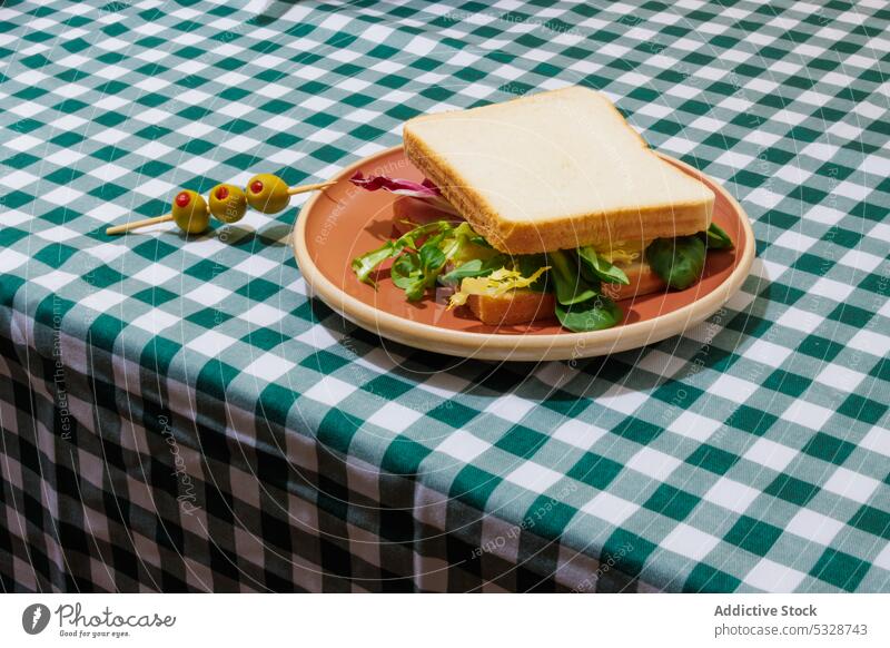 Delicious sandwich with fresh salad and olives vegetarian lettuce food meal table serve healthy plate vegetable delicious cuisine appetizing lunch checkered