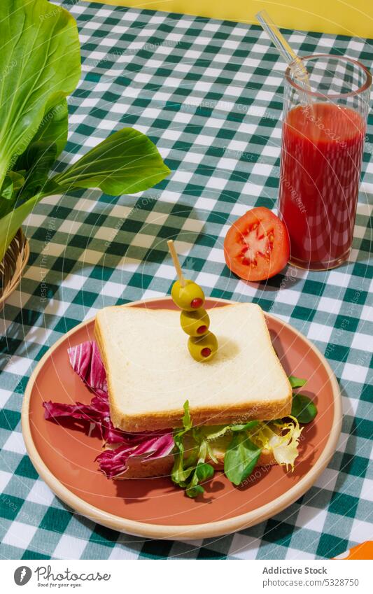 Delicious smoothie and healthy sandwich on checkered tablecloth salad tomato juice lettuce healthy food refreshment drink breakfast lunch eco friendly