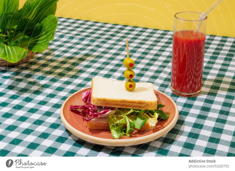 Delicious smoothie and healthy sandwich on checkered tablecloth salad tomato juice lettuce healthy food refreshment drink breakfast lunch eco friendly beverage