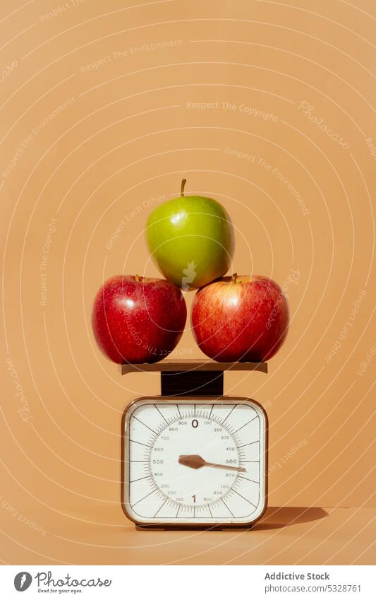 Ripe apples on weight scale against colored background fruit diet vitamin healthy food concept fresh ripe green organic nutrition delicious tasty vegetarian