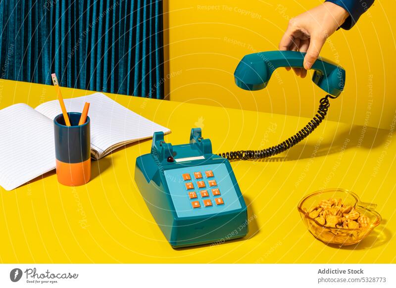 Person hanging up phone placed near office supplies person hang up handset retro stationary telephone notebook planner cookie supply old fashioned vintage
