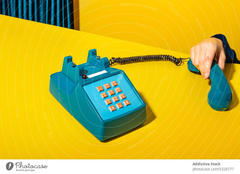 Person picking up phone on yellow background person pick up hang up handset retro stationary telephone supply old fashioned vintage creative button wire device