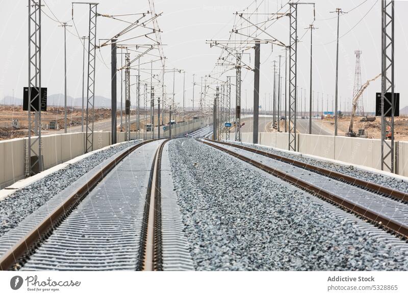 Railroad with powerlines under construction in summertime railway pole railroad electric environment development industrial track parallel infrastructure