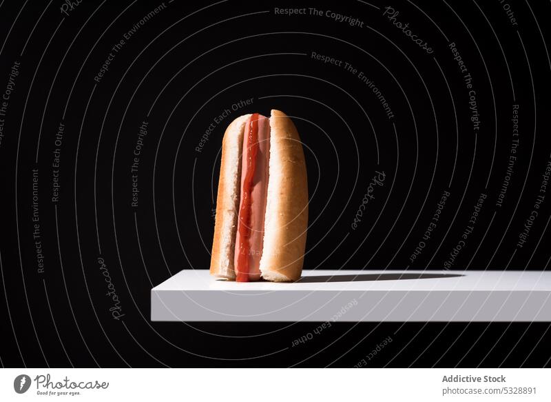 Delicious hot dog on white board over black background bun yummy fast food snack fresh delicious sweet meal nutrition appetizing tasty calorie pastry edible