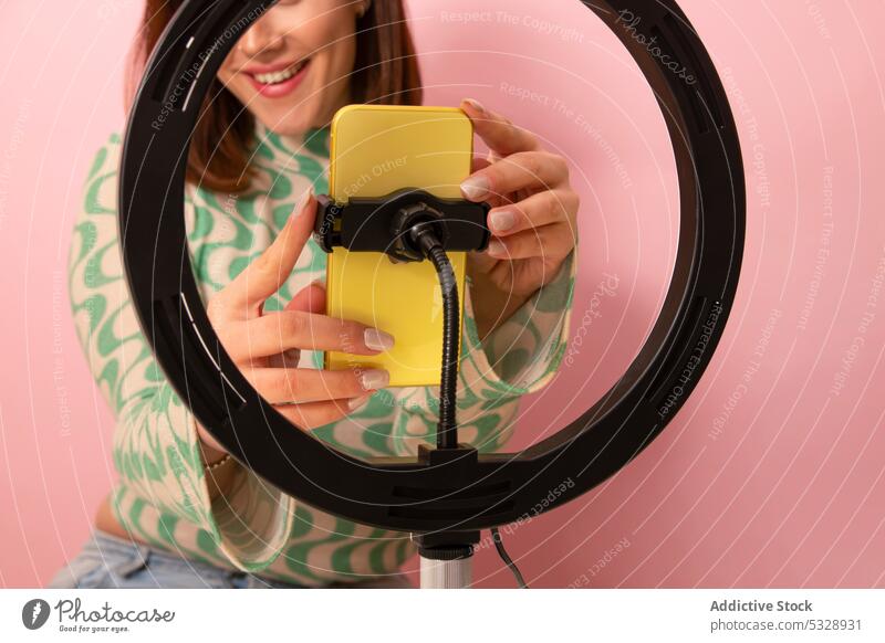 Cheerful woman recording video on smartphone blogger positive vlog using shoot ring lamp style device gadget female young trendy selfie modern mobile