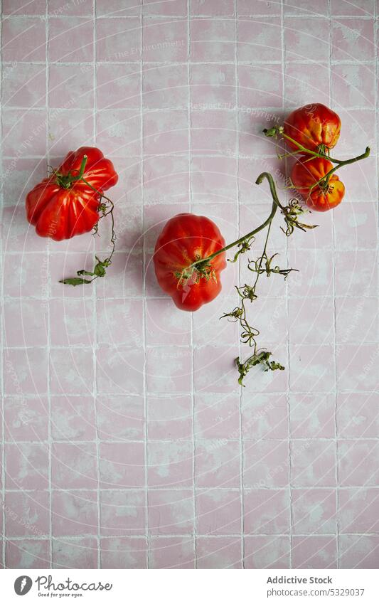 Ripe beef tomatoes on tiled floor red fresh ripe raw leaf branch vegetable stem natural food delicious gastronomy healthy tasty vitamin harvest nutrition
