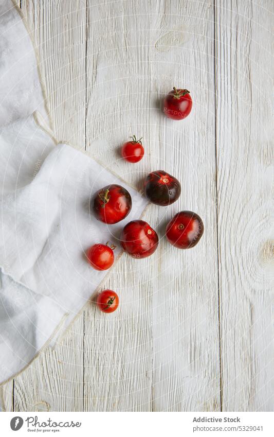 Ripe cherry tomatoes on wooden table red fresh ripe raw fabric natural food delicious healthy tasty vitamin harvest nutrition plant uncooked whole botany