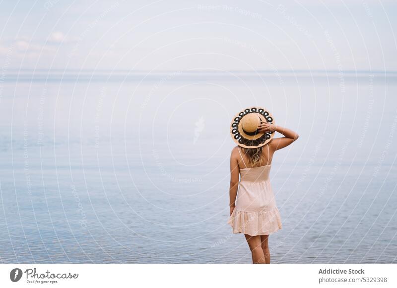 Woman in sunhat admiring seascape woman tourist admire ocean shore relax chill cloudy female model travel trip journey explore summer vacation weekend nature