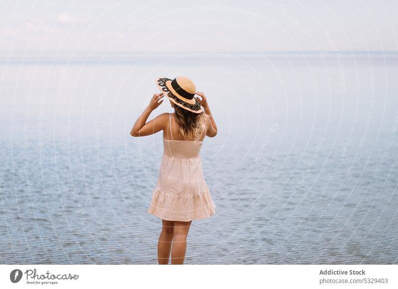 Woman in sunhat admiring seascape woman tourist admire ocean shore relax chill cloudy female model travel trip journey explore summer vacation weekend nature