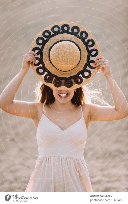 Woman covering face with hat on beach woman tourist sand sunhat relax cover face hide summer female model travel trip journey vacation holiday weekend nature