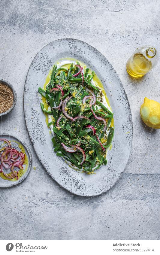 Healthy salad with fresh herbs and onion on table vegetarian oil green slice serve plate lemon dish food lunch delicious meal portion tasty cuisine culinary