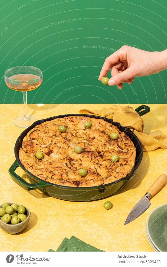 Unrecognizable person placing green olives on bread oven prepare cook wine food cuisine pan glass recipe culinary meal gourmet serve baked alcohol home red wine