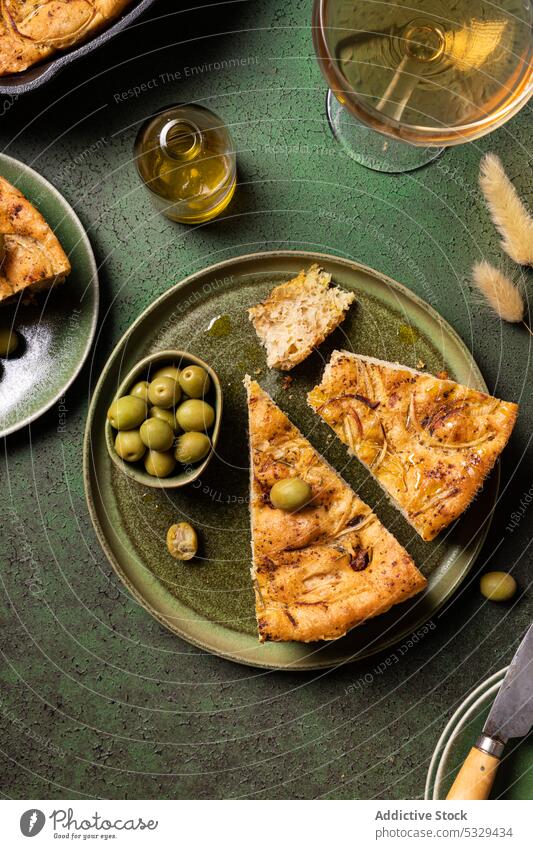 Delicious focaccia bread piece with green olives served on plate fork knife baked food tradition nutrition table oven italian delicious culinary meal cook