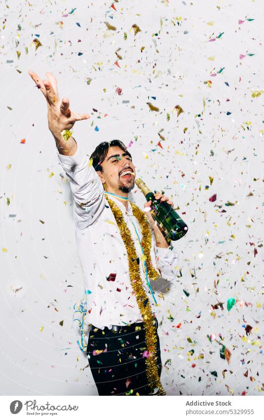 Drunk bearded man with bottle of champagne during Christmas holiday party christmas drunk sing microphone celebrate confetti portrait festive alcoholic formal